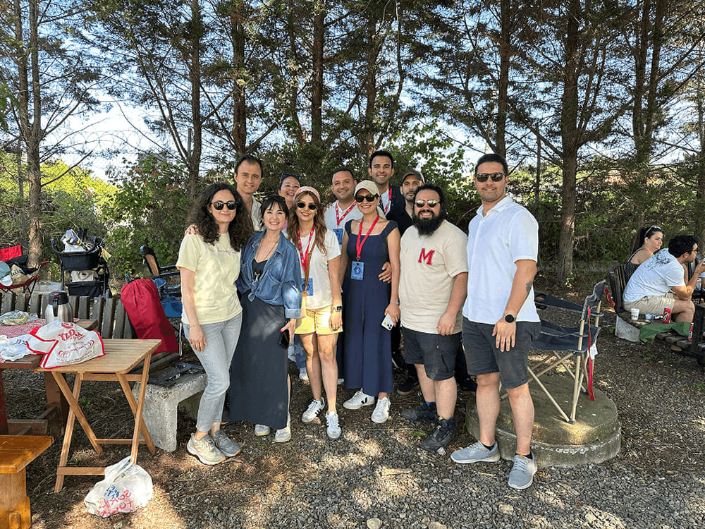 Işık University alumni and their families sitting on the grass during the 2nd Alumni Picnic at the Şile campus.