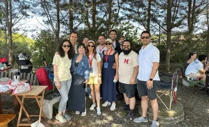 Işık University alumni and their families sitting on the grass during the 2nd Alumni Picnic at the Şile campus.
